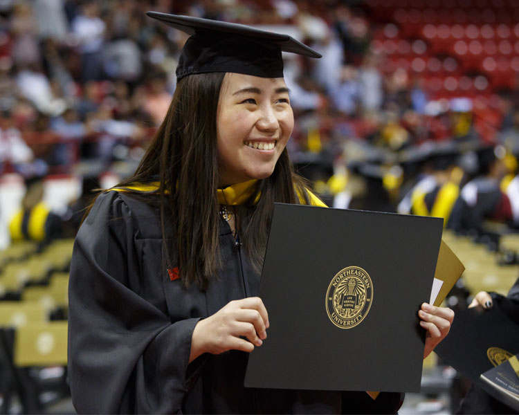 Northeastern student with diploma at graduation