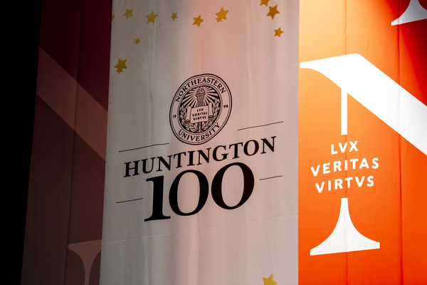 The Huntington 100 banner hanging in front of a large Northeastern banner. Photo by Ruby Wallau/Northeastern University