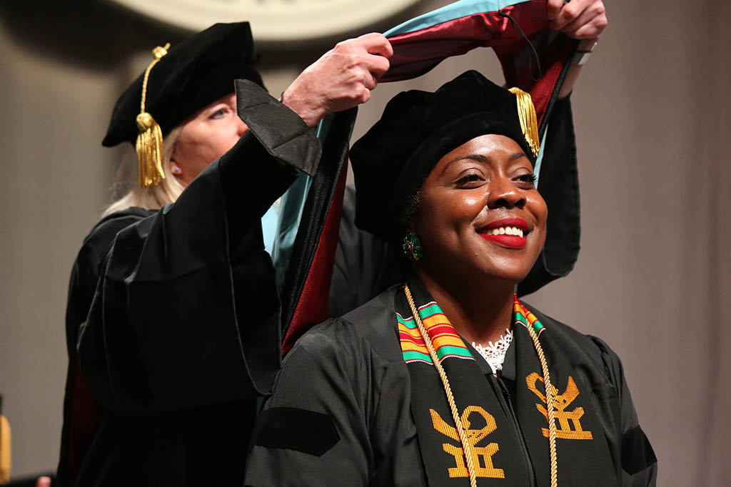 Female CPS Doctoral graduate presented with doctoral hood by their faculty adviser at the May 2022 CPS Doctoral Hooding Ceremony