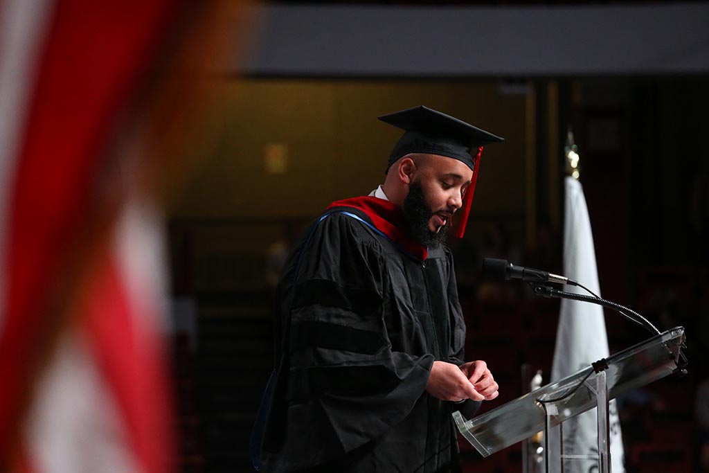 Jeffrey Lopes gives the alumni greeting on stage at the 2022 May CPS Graduation Ceremony. Photo by Heratch Ekmekijan