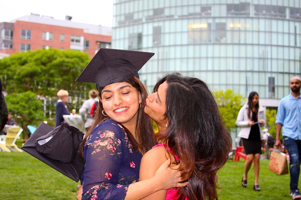 Two female CPS graduates hug each other at Centennial Common at the 2022 May Pre-Graduation Celebration. Photo by Denise Reid
