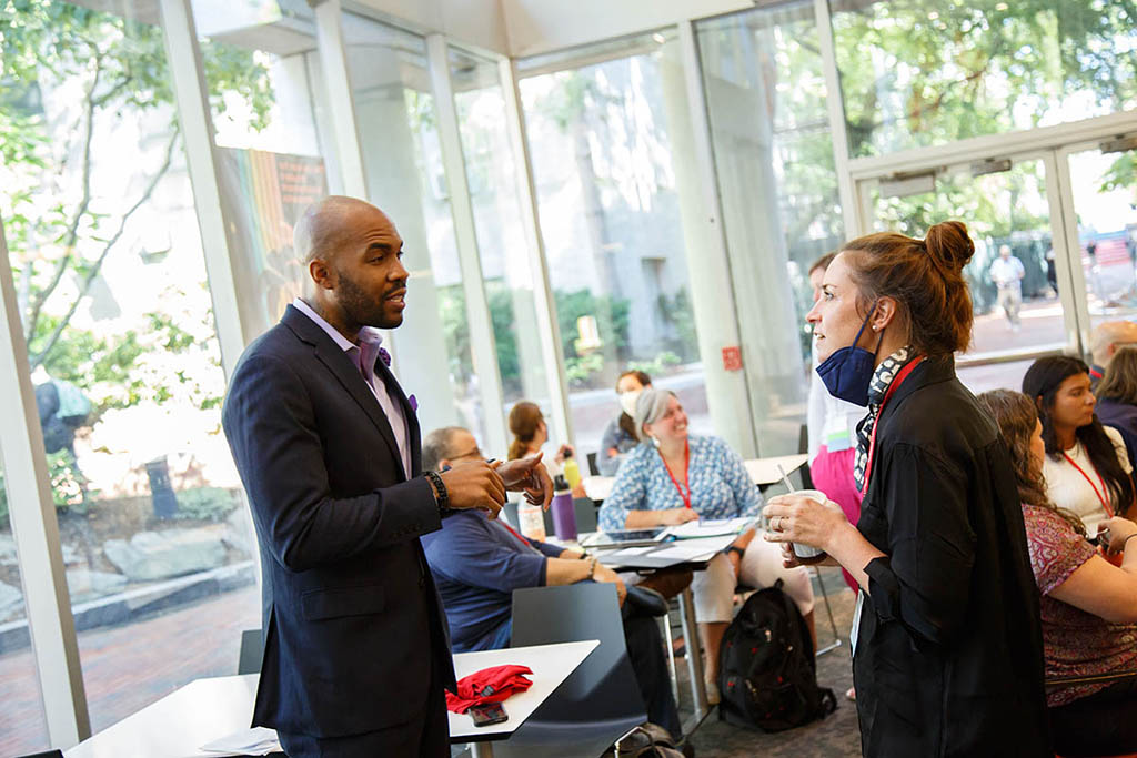 Jae Williams speaks with guests at an EdD networking event. Photo by Heratch Ekmekijan